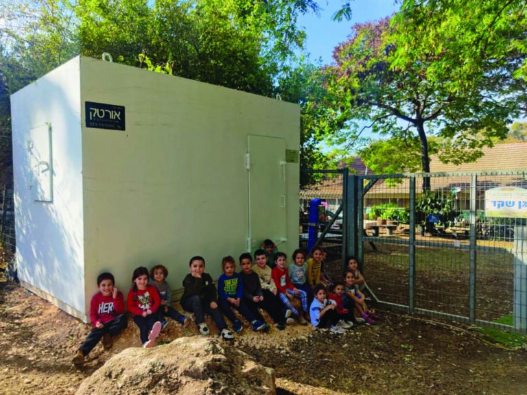 Children sit outside their new bomb shelter at kibbutz Kfar Hamaccabi.