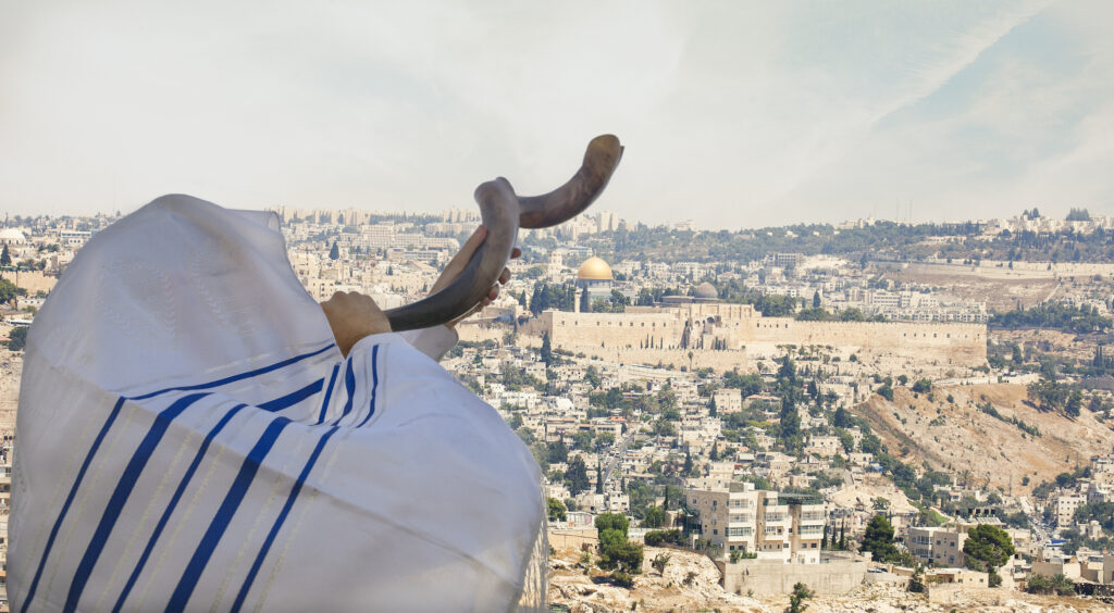 Close up on man Man with Shofar with Jerusalem old city view.