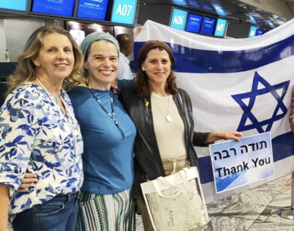People standing together holding flag and thank you sign