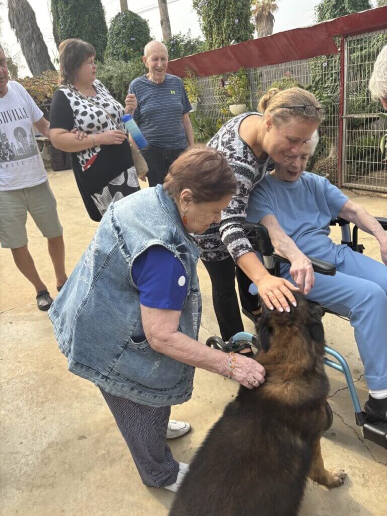 Holocaust survivors Sheila (L) and Sonja (Ri) are so happy to pat a dog at the petting zoo